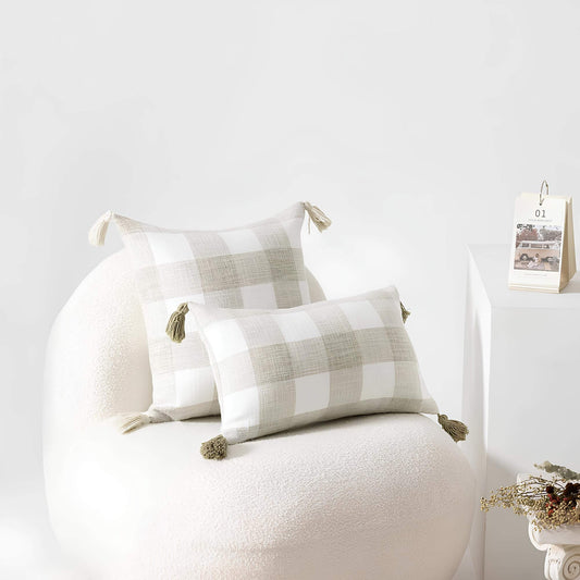 Coussin beige à rayures et pompons
