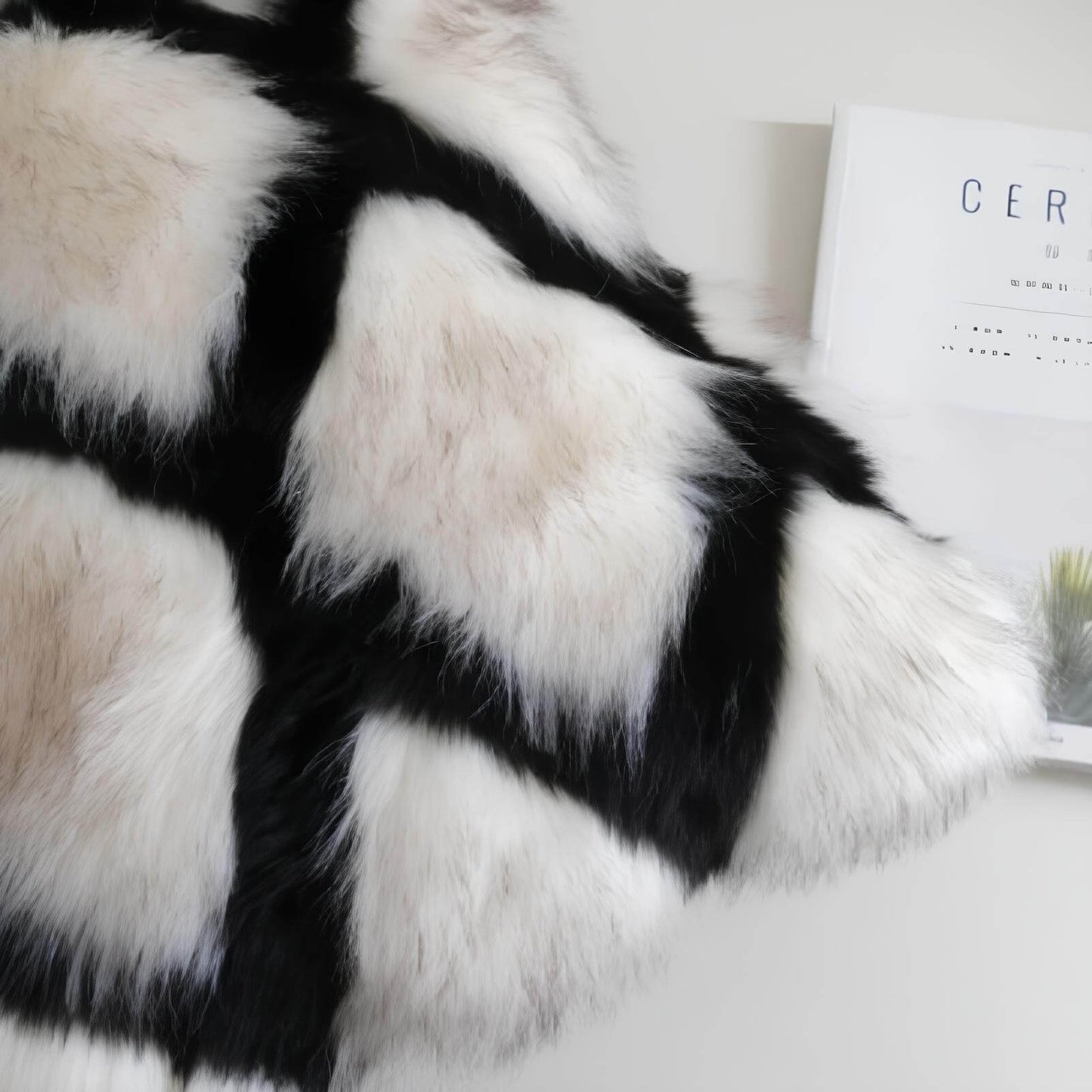 Coussin noir et blanc en fausse fourrure